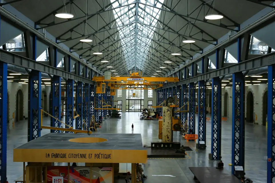 An industrial hall with machinery and high ceilings.